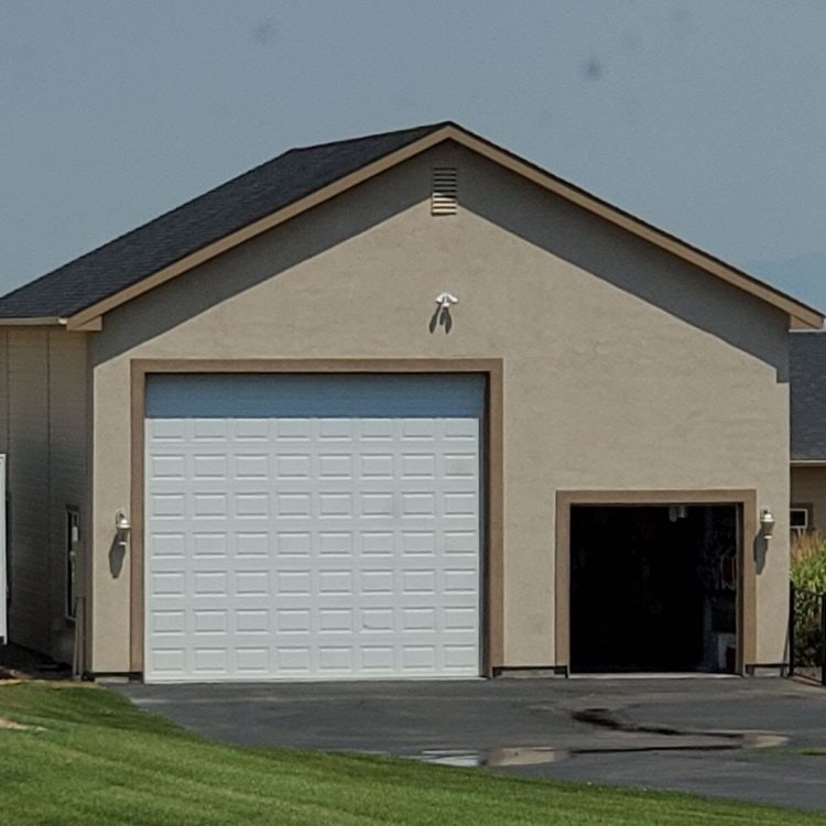 Completed residential garage with overhead door and clean finishing by Jedd Shippy LLC in Caldwell, ID